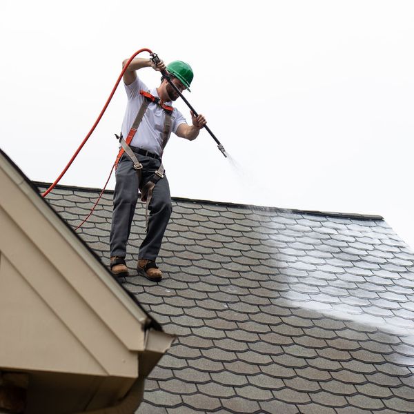 Man spraying roof with Roof Maxx Treatment