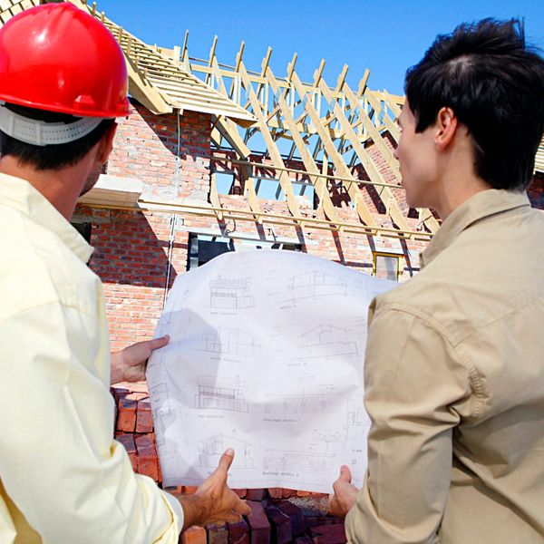 Roofing contractor showing blueprint to client