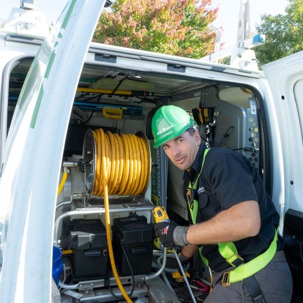 roofer getting the roof maxx application system out of their van