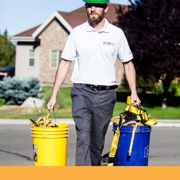 roofing contractor carrying harnesses to a job site