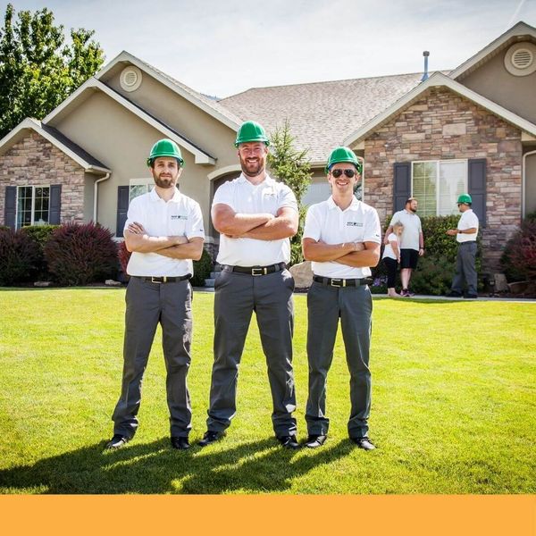 Guaranteed Roofing team in front of a house