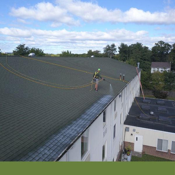 roofing contractor spraying the top of roof