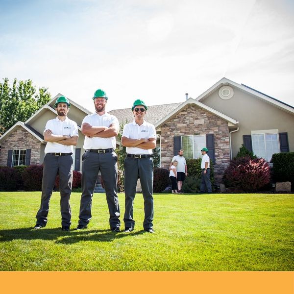 The Guaranteed Roof team standing outside a house