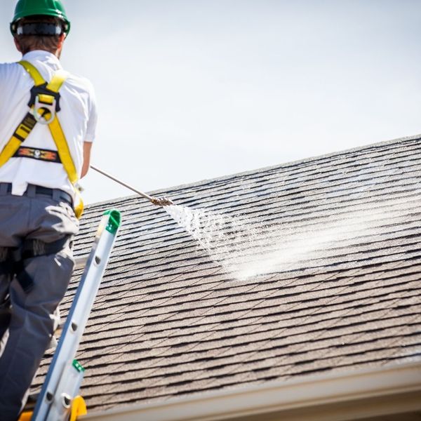 Guaranteed Roof employee spraying roof