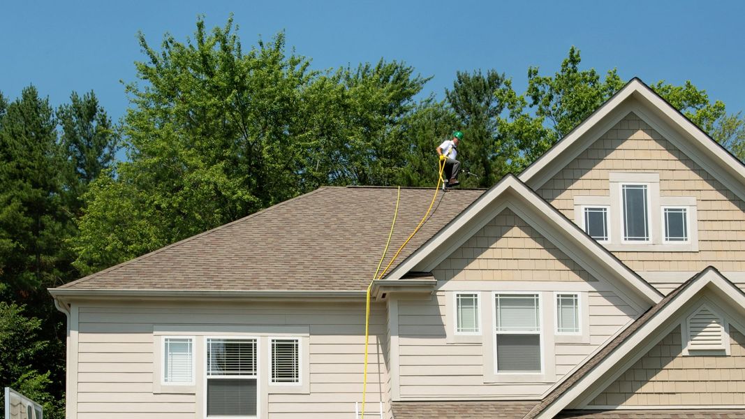 Man on top of roof cleaning it