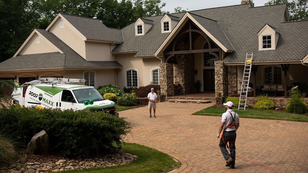 Roofers in front of a house they're working on