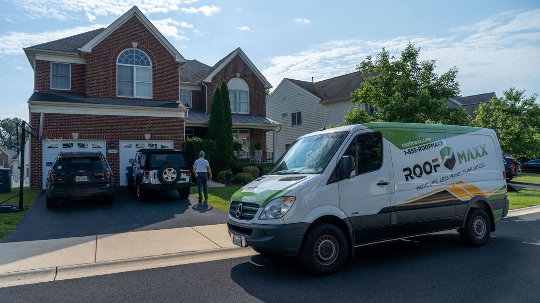 Roof Maxx van in front of a house Roof Maxx van in front of a house