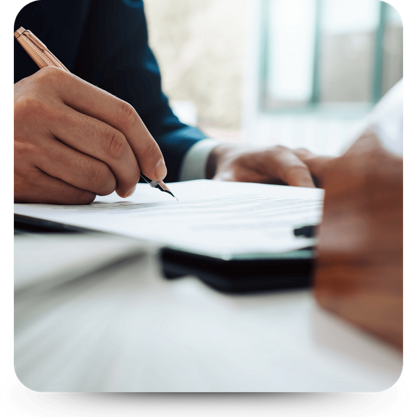 Image of a person signing a paper Image of a person signing a paper