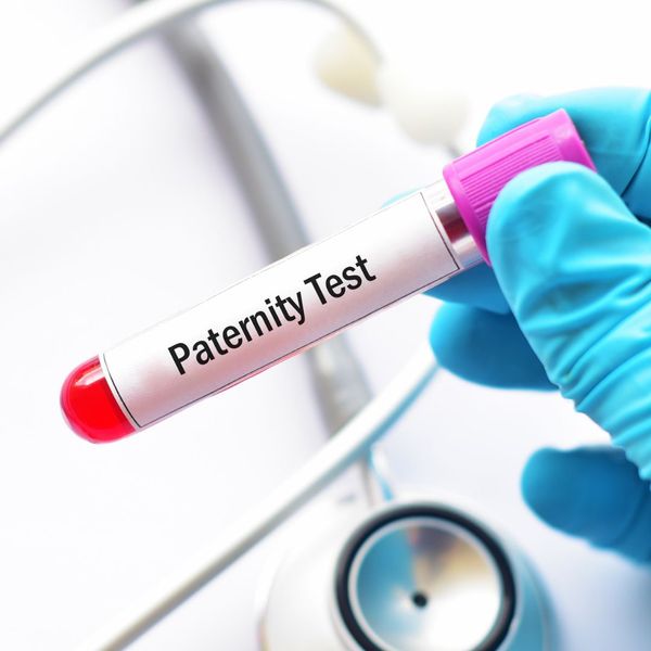 Person holding a vile of blood with a label that says "Paternity Test".
