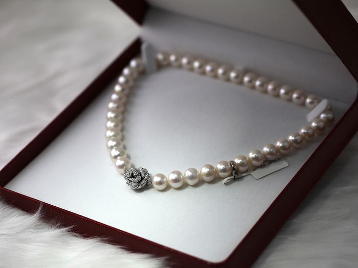 Image of a pearl necklace with diamond pendant in box