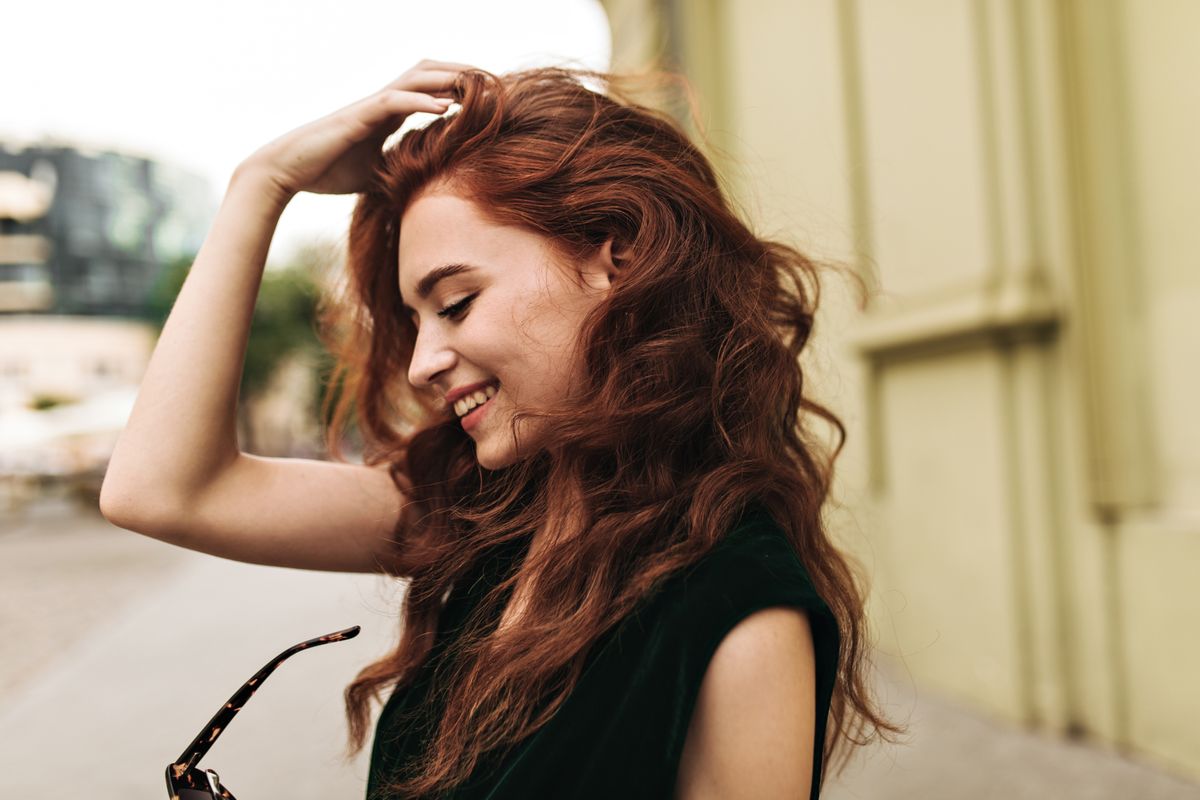curly-woman-putting-off-sunglasses-and-smiling-2024-09-23-23-20-22-utc.jpg