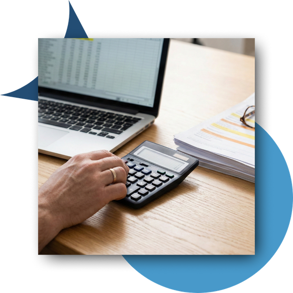 Accountant using a calculator while looking at a spreadsheet