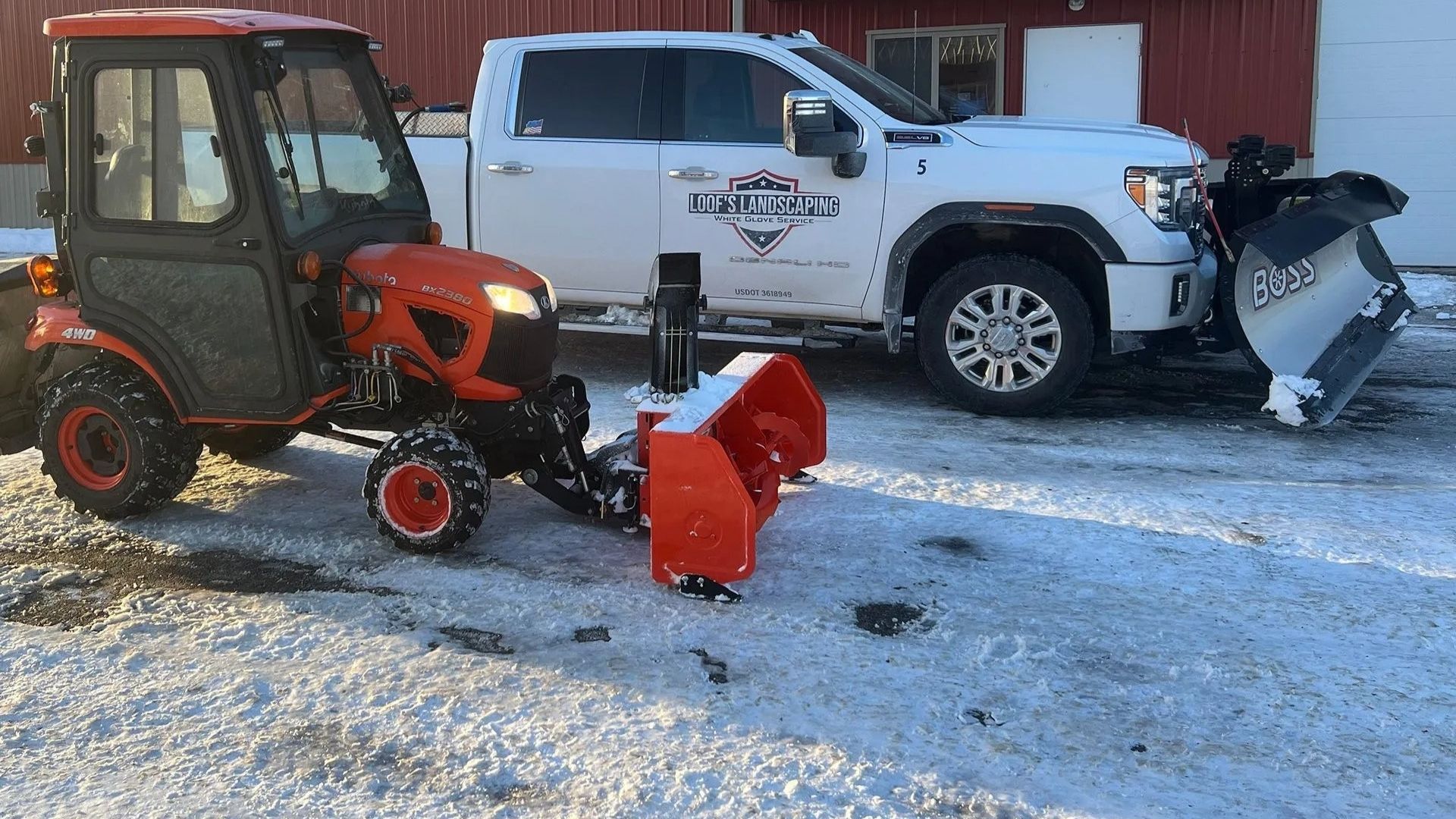 Snow and ice management equipment, showing a white Loof's Landscaping truck with a snow plow parked next to an orange Kubota compact tractor with a snow blower attachment.