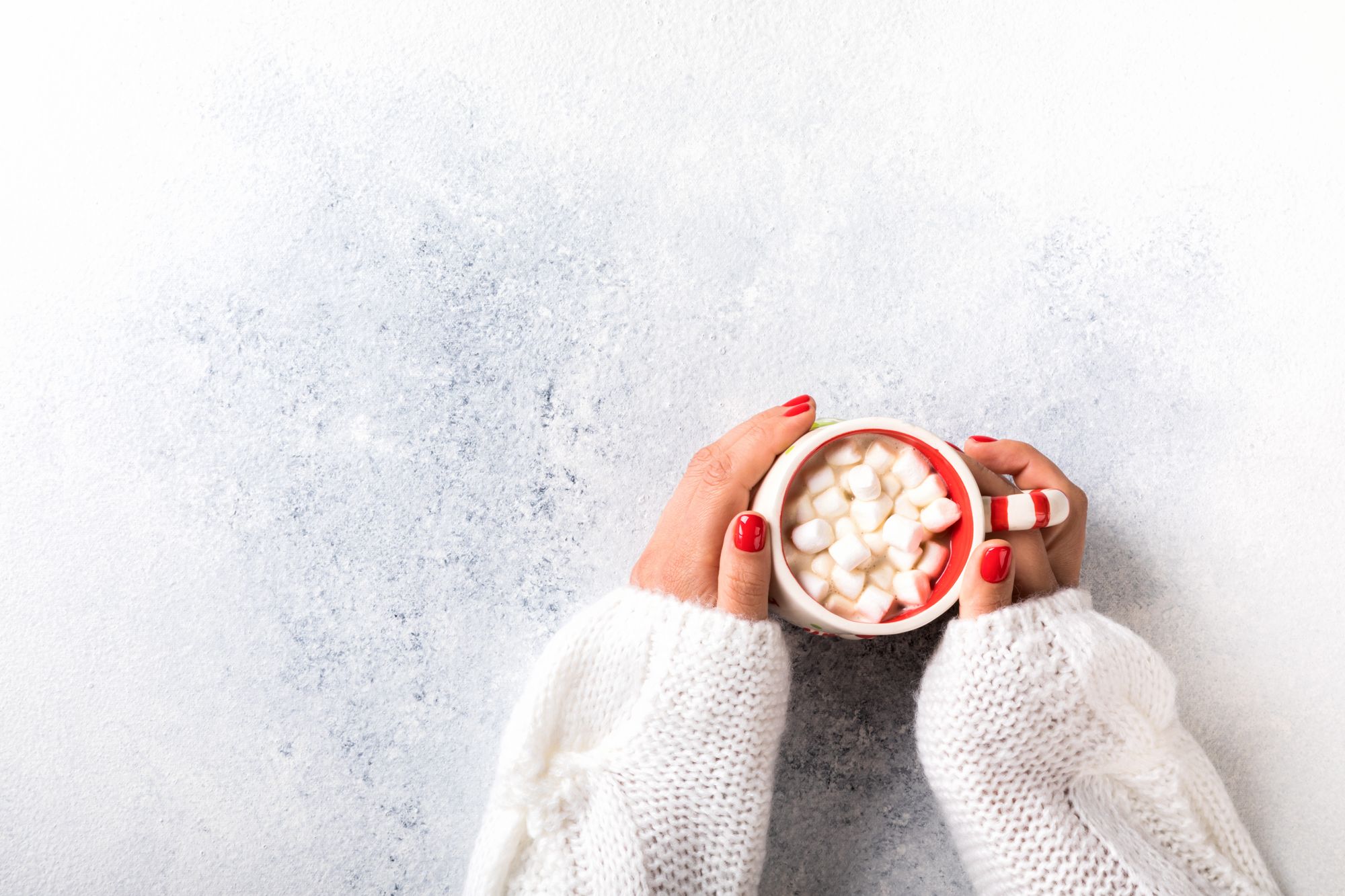 female-hands-hold-a-cup-of-coffee-with-marshmallow-GPCKRTG.jpg