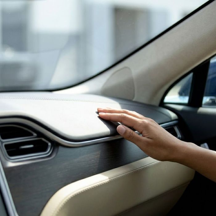 a hand resting gently on the passenger dashboard, highlighting the seamless integration with the flawless windshield.