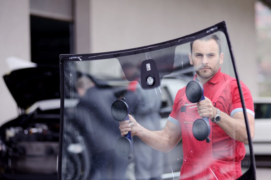 A man holding a windshield