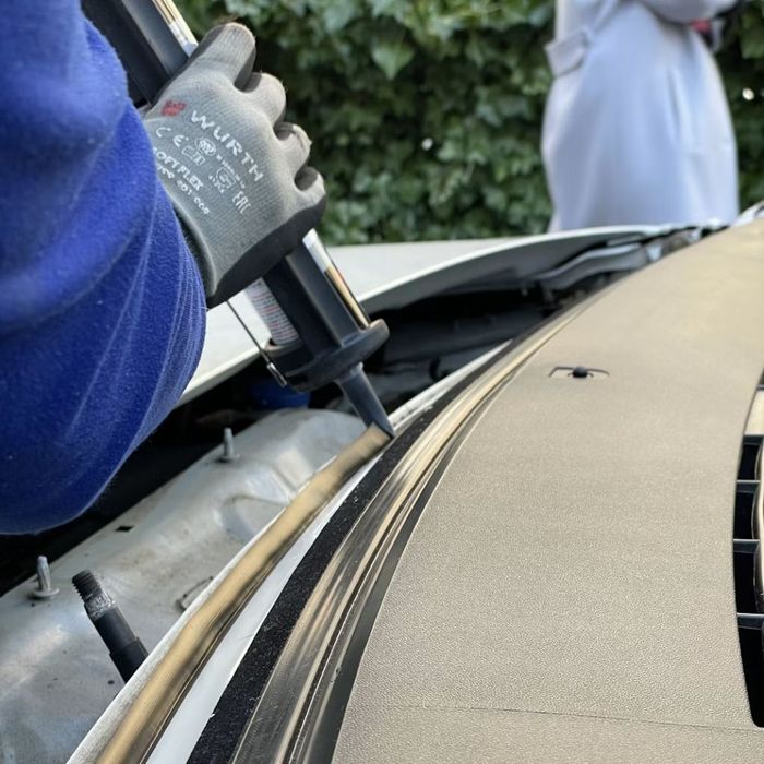 windshield adhesive being applied to car
