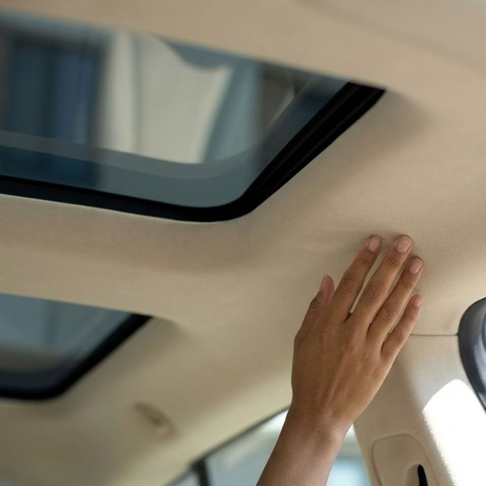 A close-up looking up at the closed sunroof and headliner