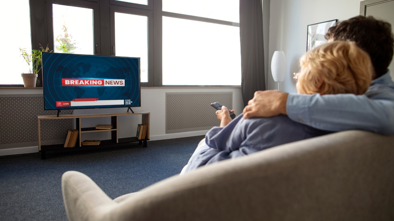 couple-on-a-couch-watching-tv-news.png