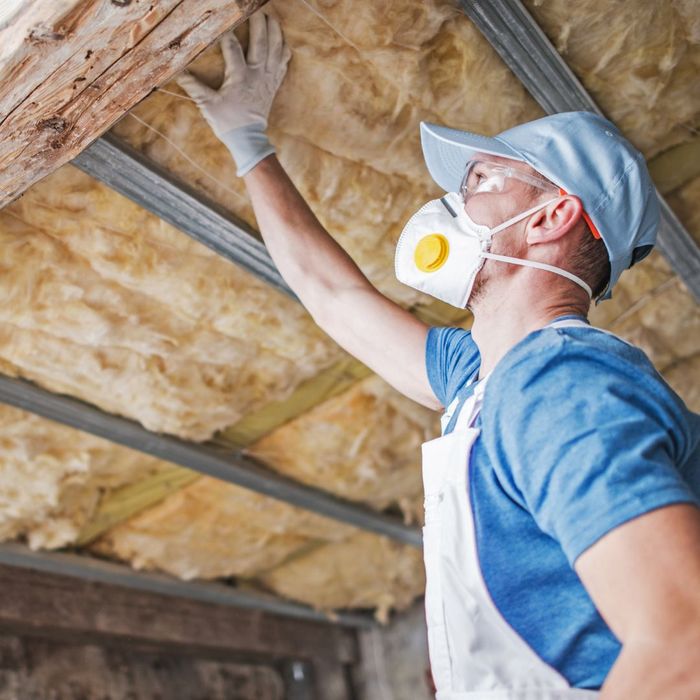 worker patting roof insulation