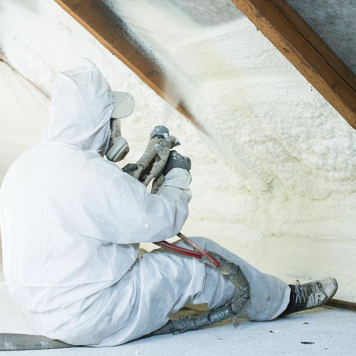roofer spraying foam insulation in a roof