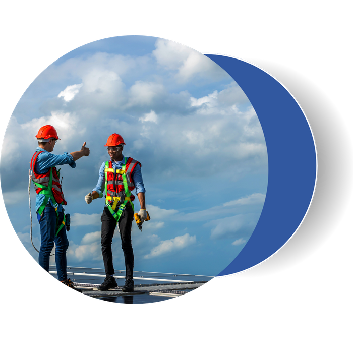 Two roofing contractors in safety gear standing on a commercial roof