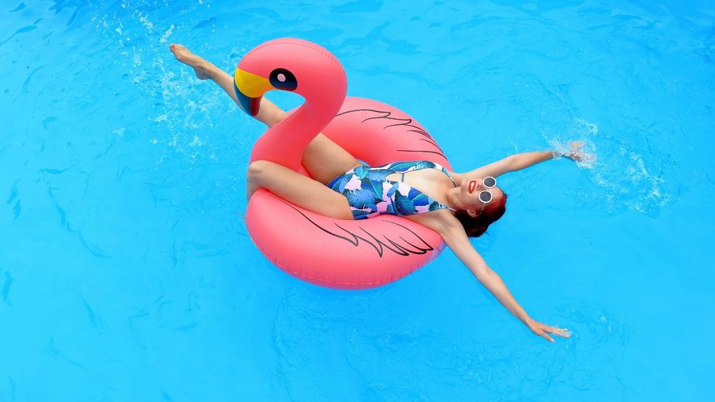 woman lounging in a pool with a flamingo floaty
