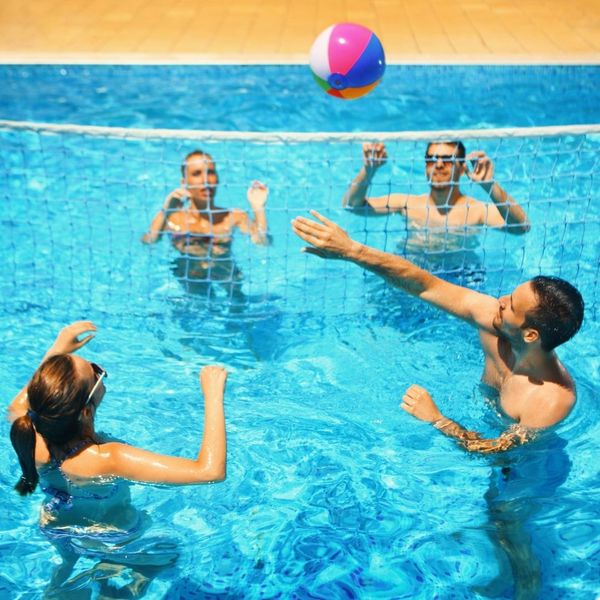 friends playing volleyball in a pool