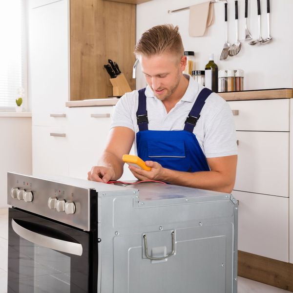 Maintenance man fixing a stove