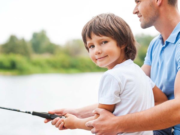 Man and son fishing on river