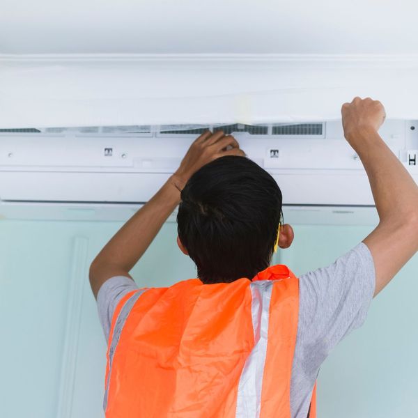 maintenance staff member fixing an AC unit maintenance staff member fixing an AC unit