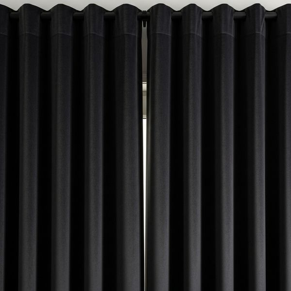 Close-up of heavy, dark blackout curtains drawn over a window.