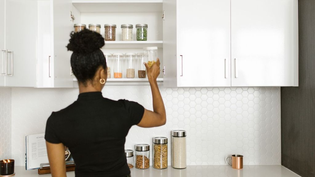 woman looking in her kitchen cabinet