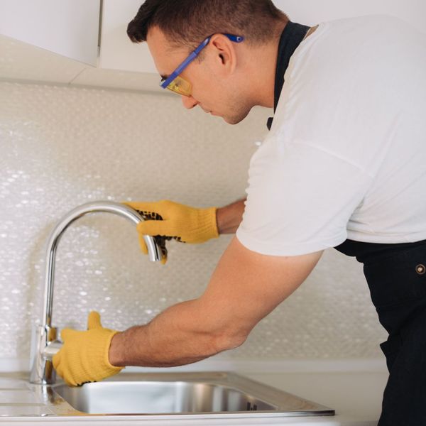 maintenance person installing a faucet