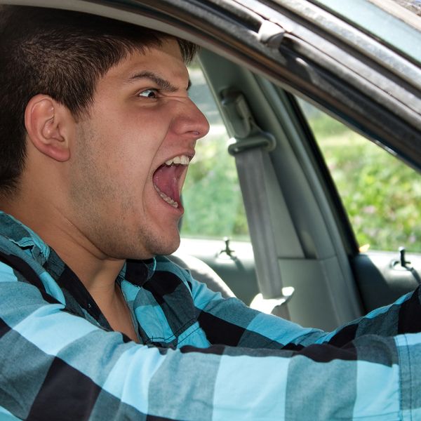 Image of an angry man screaming in his car