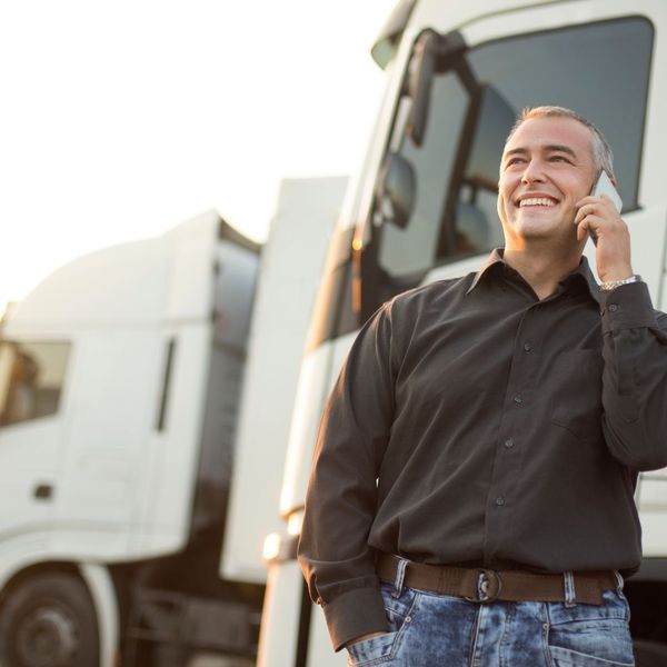 man talking on a phone beside a truck