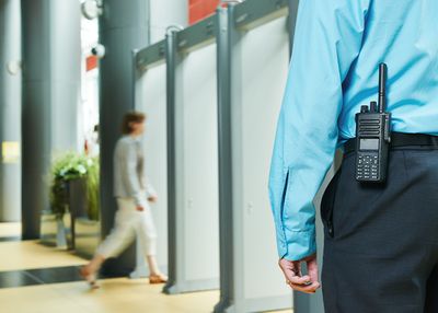 a guard inside a business with metal detectors