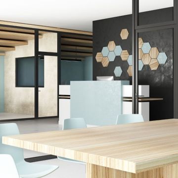 Modern commercial office reception area after a professional remodel, featuring a custom desk and wood-panel wall art.