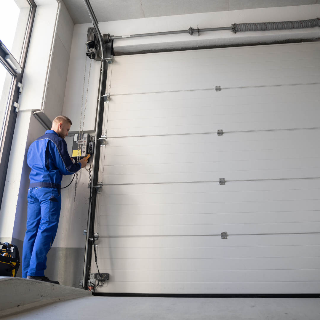 Technician servicing the track and hardware of a sectional garage door