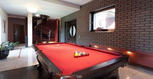 A big red pool table in a luxurious interior.
