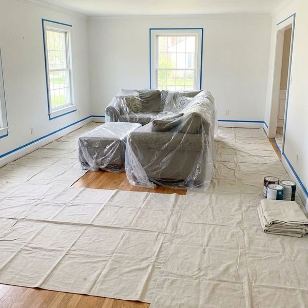 furniture and floors covered with paint tarps