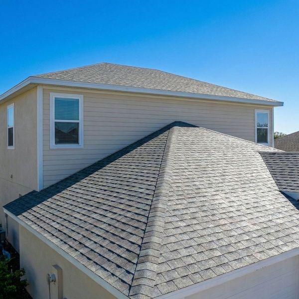 A newly installed architectural shingle roof gleaming under the bright Florida sun.