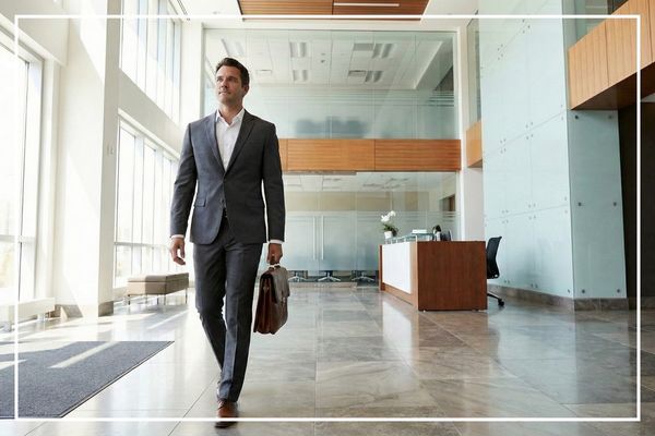 man in a suite walking into a lobby