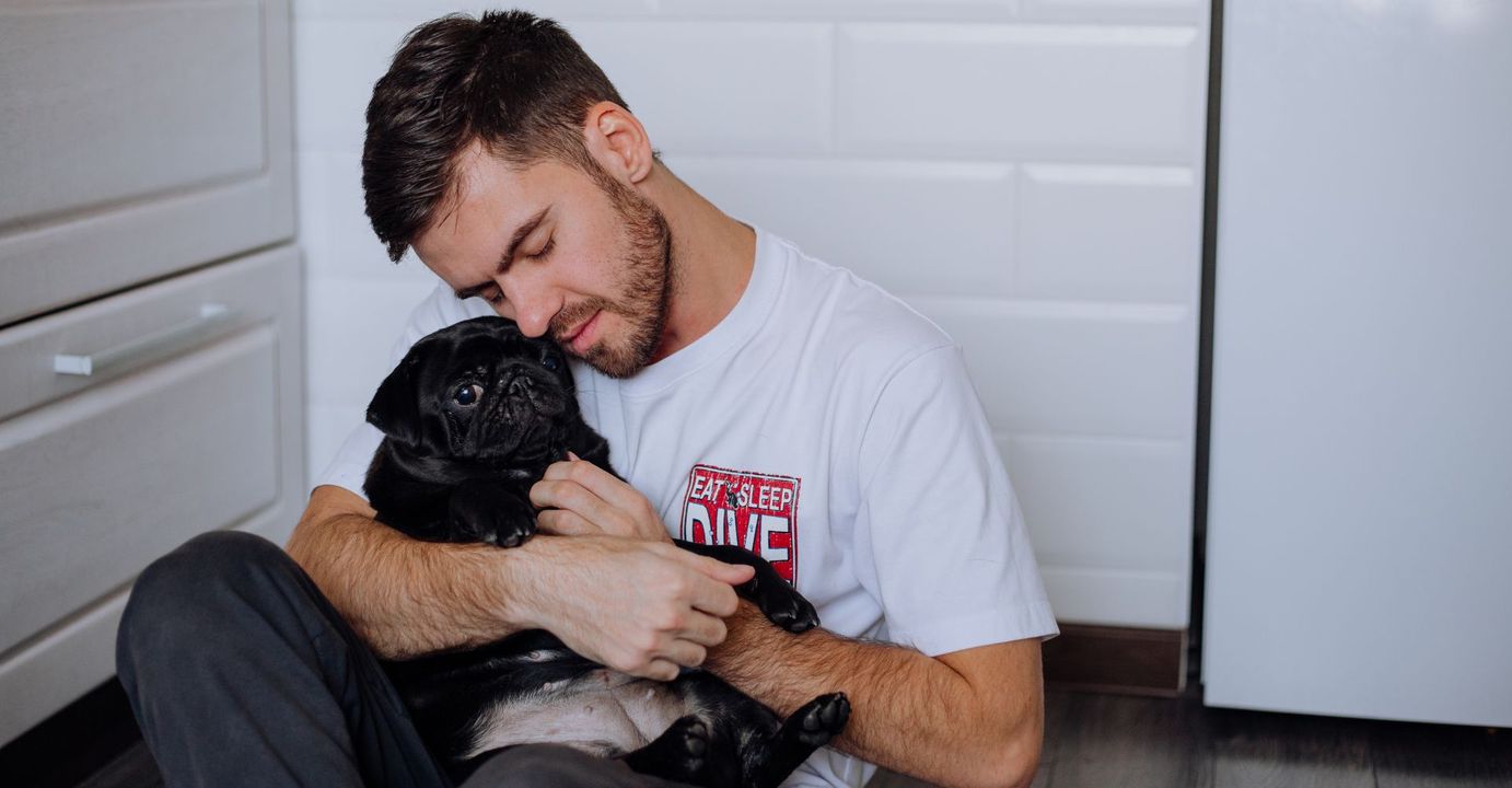 man hugging his dog