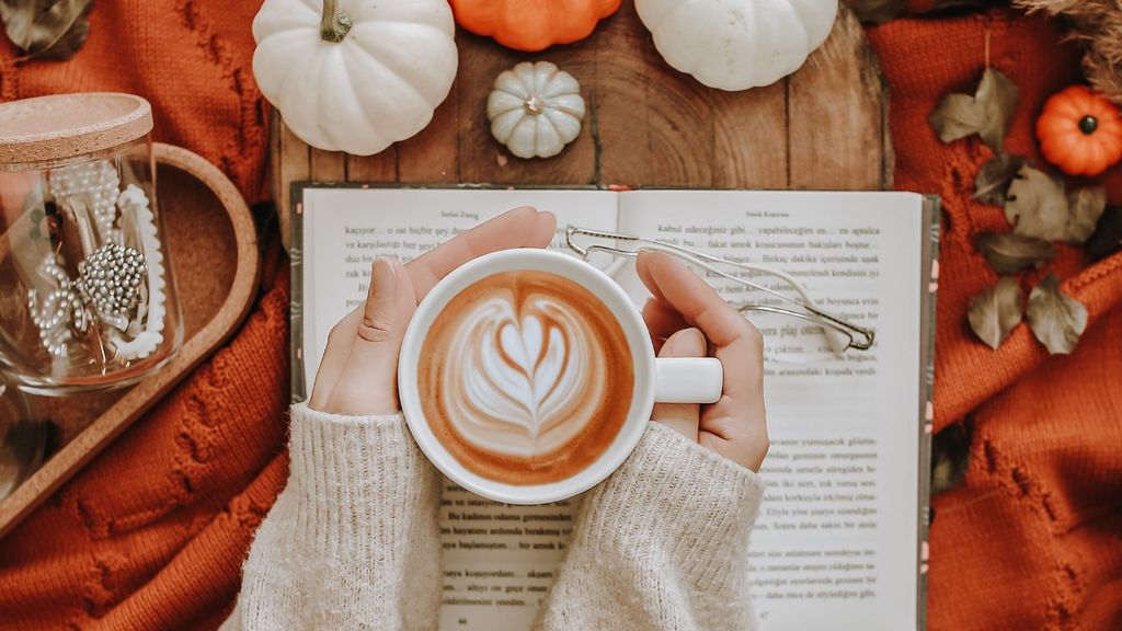 fall decor and a person holding a hot drink fall decor and a person holding a hot drink