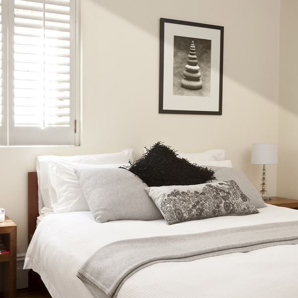 A nice modern bedroom with natural light shining on the well-made bed. 