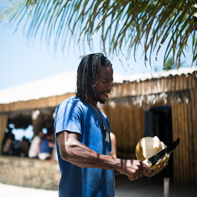 Jamaican man cutting a coconut