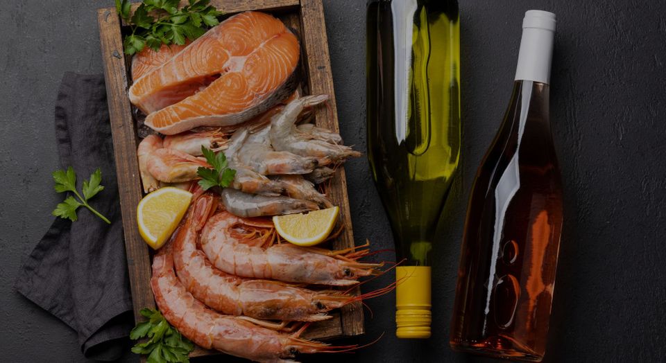 plate of seafood next to a bottle of red and white wine