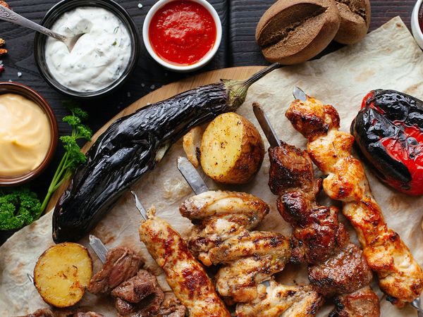 A plate of jerk chicken and other roasted meats and vegetables.