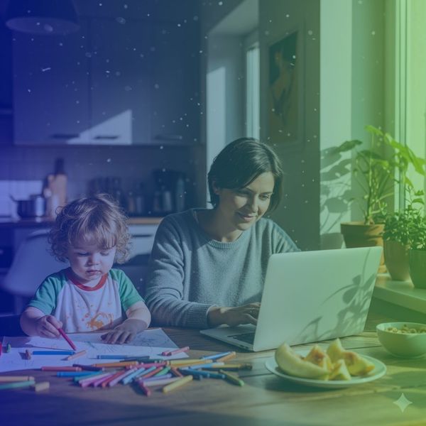 Parent working on laptop with toddler next to her